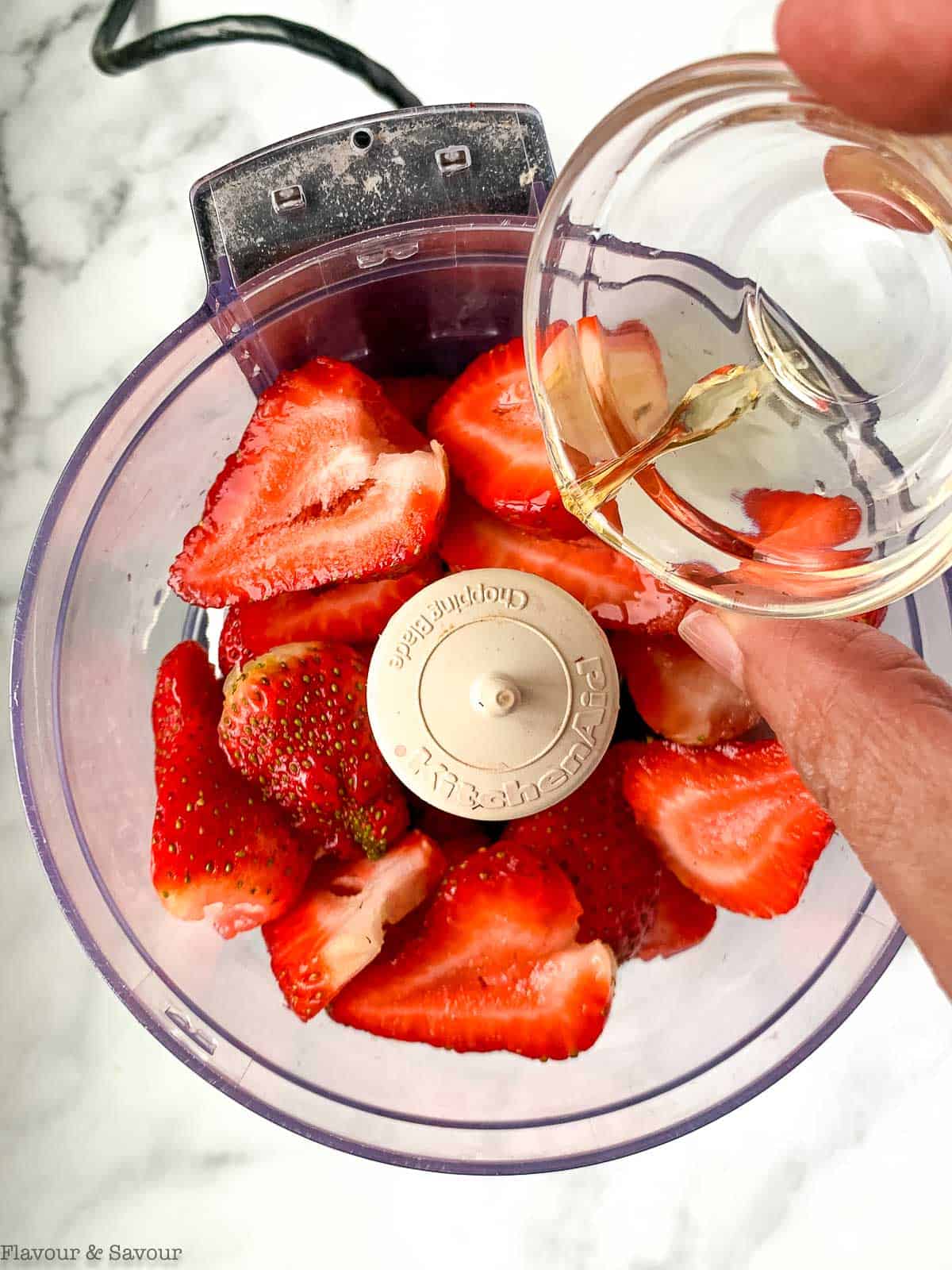 adding vinegar to strawberries in a food processor.