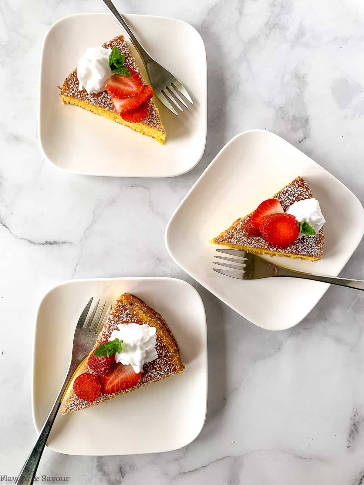 3 slices of one-bowl flourless almond cake with strawberries and almond whip.