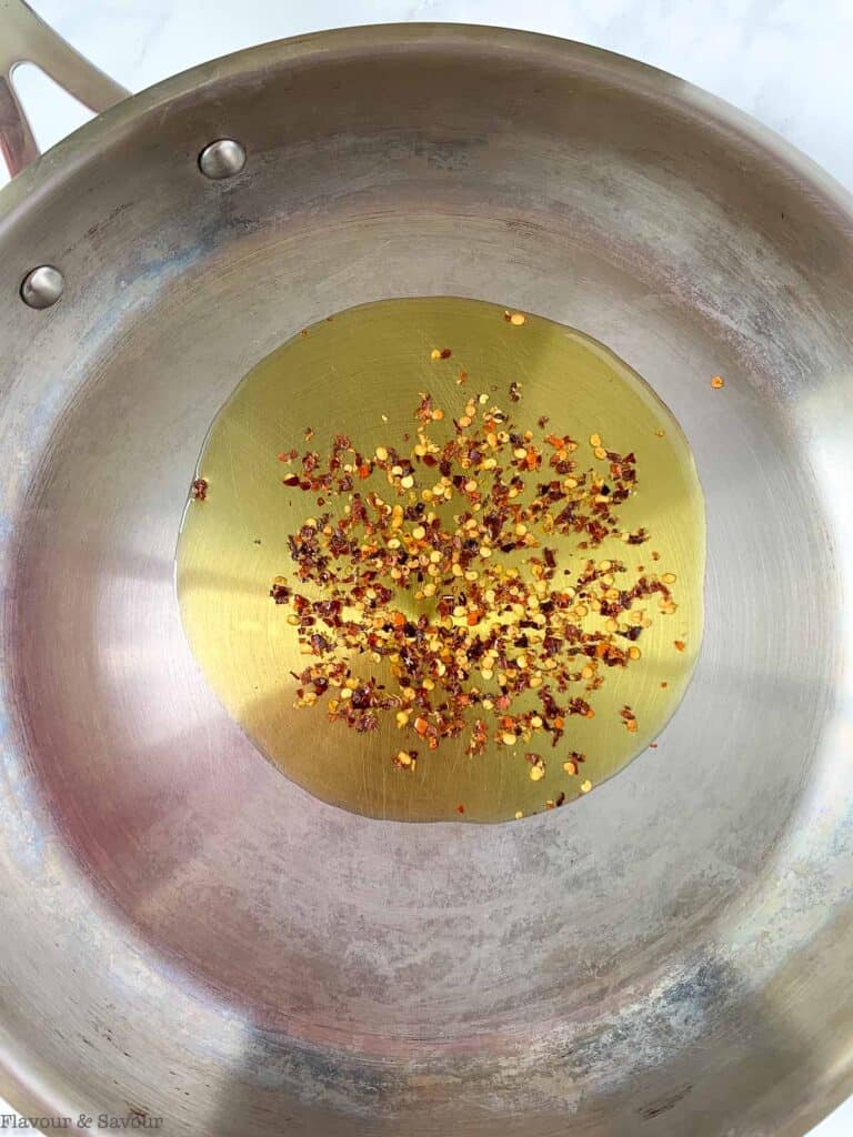 softening dried chili flakes in olive oil in a skillet.