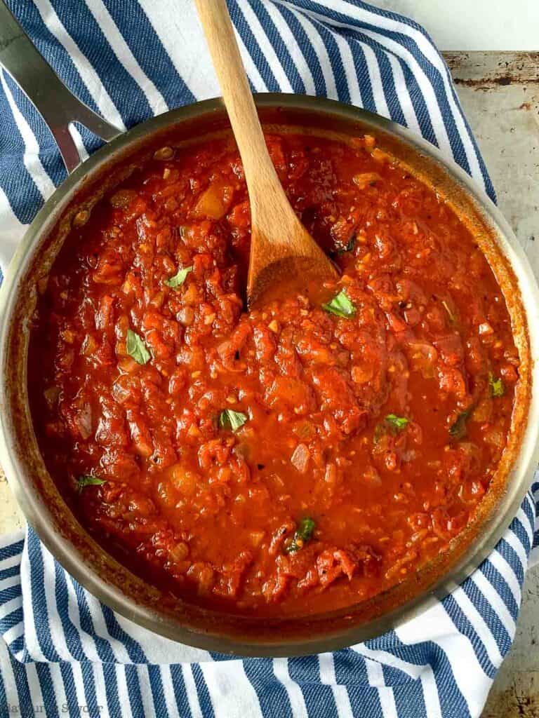 simmer arrabbiata sauce with basil leaves.