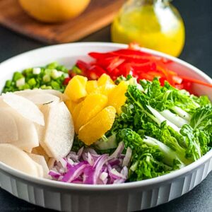 baby bok choy salad ingredients in a shallow white bowl.