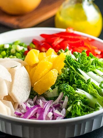 baby bok choy salad ingredients in a shallow white bowl.