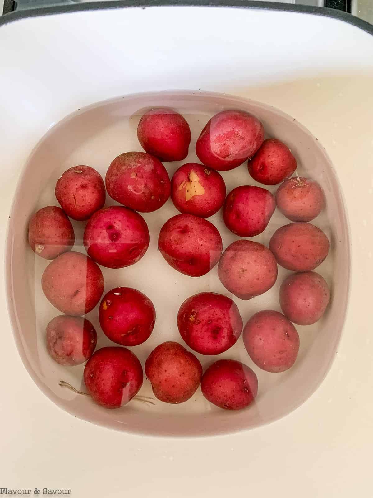 baby potatoes in a Dutch oven covered with water.