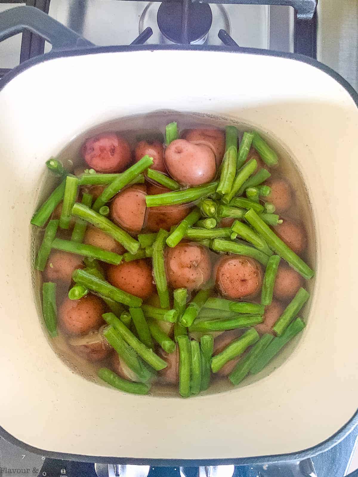 Green beans and potatoes in boiling water.