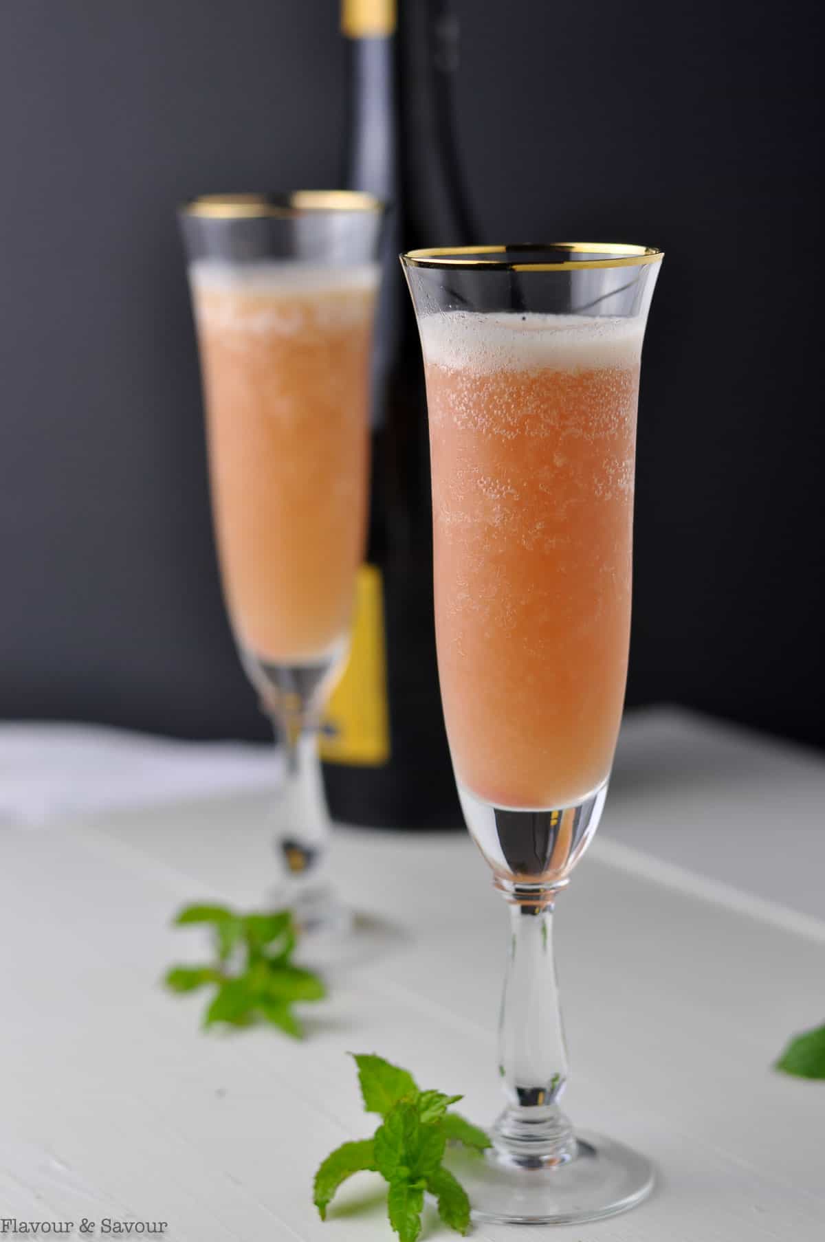 Pouring Prosecco into fluted glasses to make Rhubarb Bellini Prosecco Cocktails.