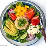 overhead view of a quinoa bowl with strawberry, mango and avocado.