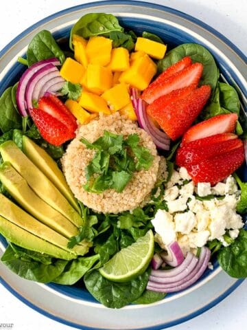 overhead view of a quinoa bowl with strawberry, mango and avocado.