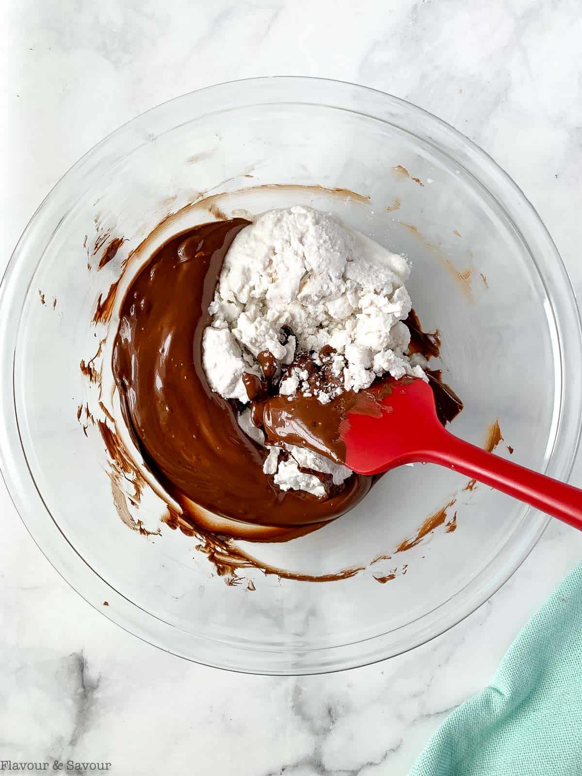adding coconut milk to melted chocolate