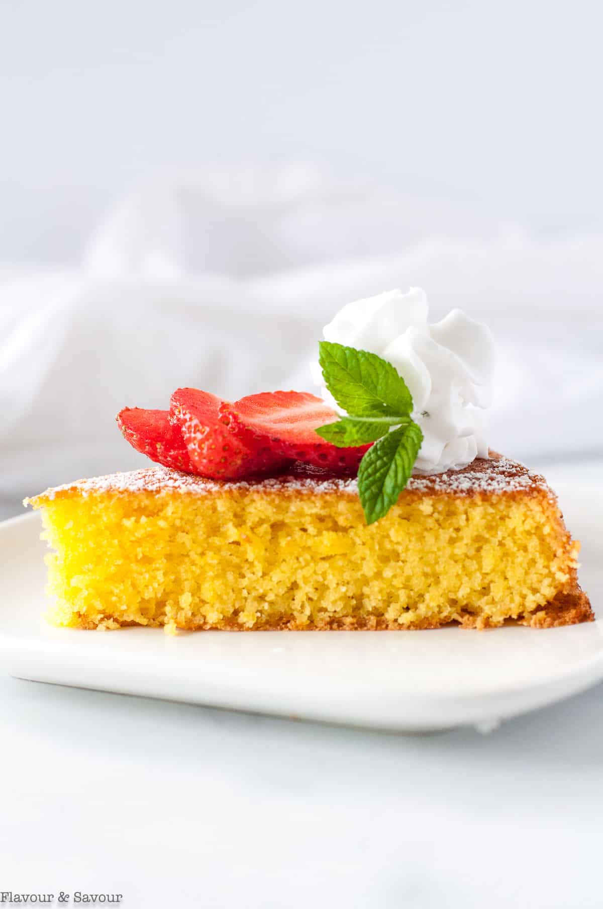 close up view of a slice of flourless lemon almond cake.