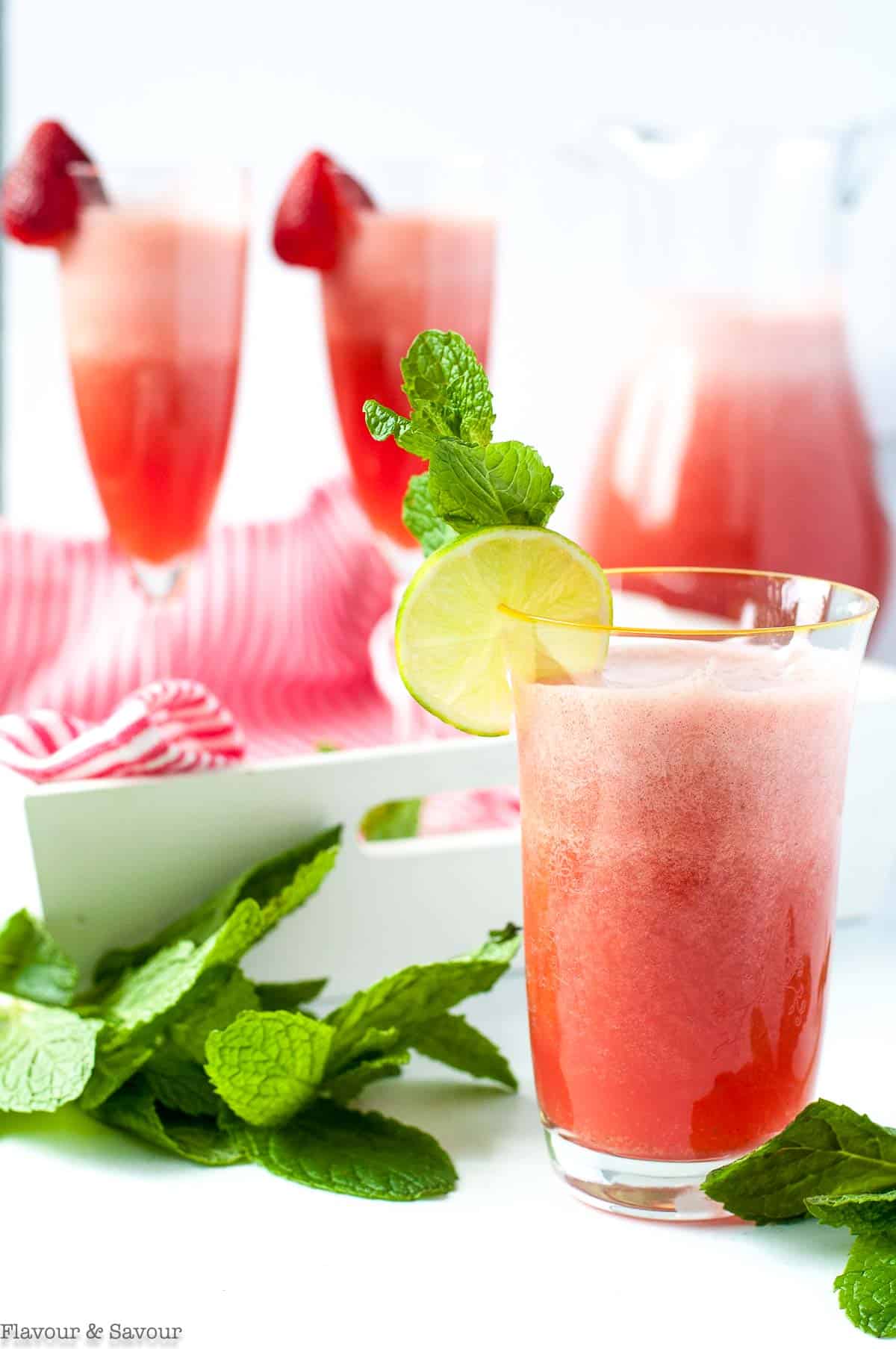 Sparkling Strawberry Limeade in flutes and a tall glass.