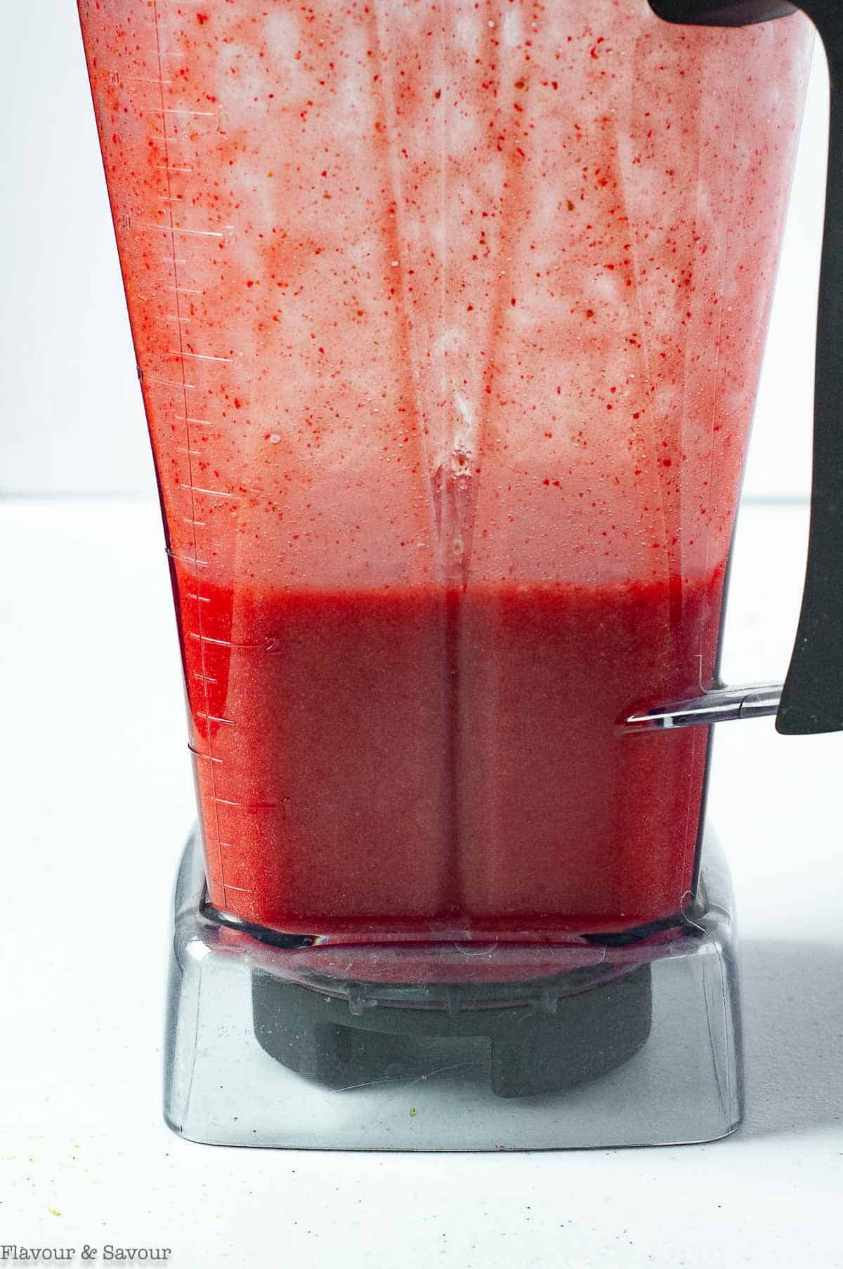 Sparkling strawberry limeade mixture in a blender container.