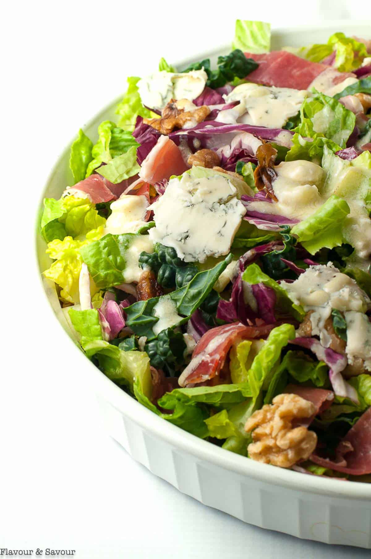 tuscan salad with creamy gorgonzola dressing in a shallow white bowl.