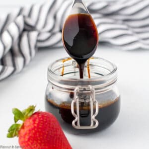 Balsamic glaze drizzled from a spoon.