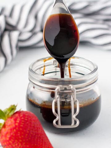 Balsamic glaze drizzled from a spoon.