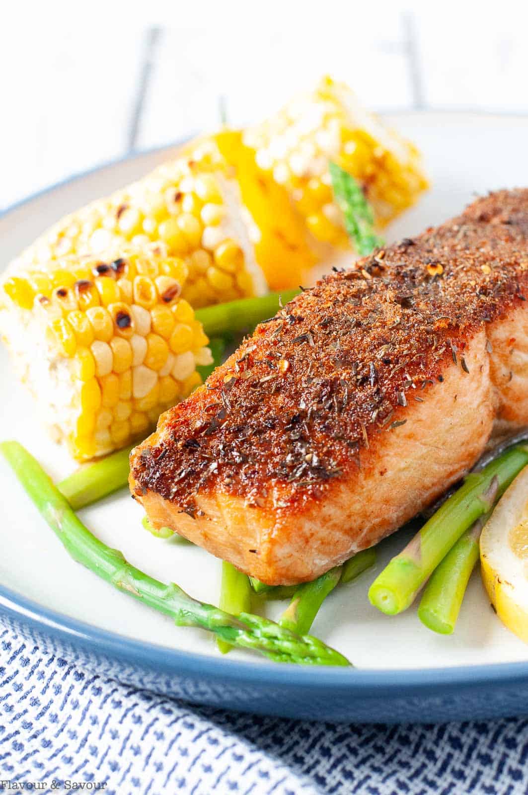 Close up view of Cajun spiced salmon fillet with corn on the cob.