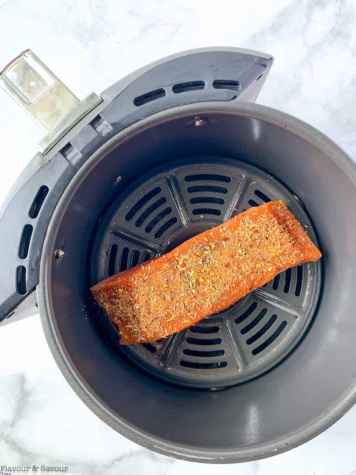 A salmon fillet in an air fryer basket.