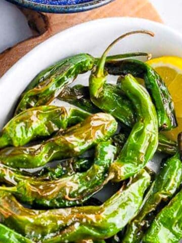 A bowl of shishito peppers cooked in an air fryer.