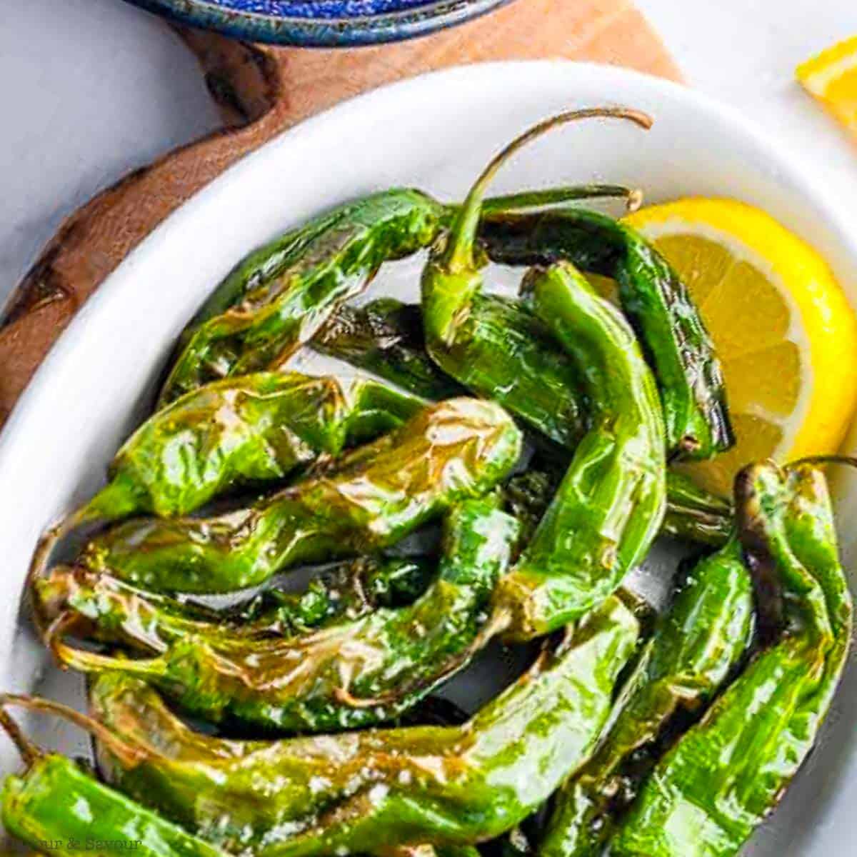 A bowl of shishito peppers cooked in an air fryer.