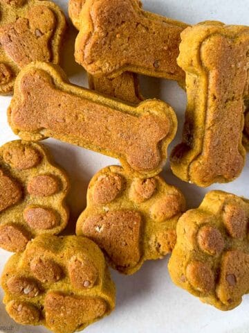Homemade peanut butter dog treats in a pile.