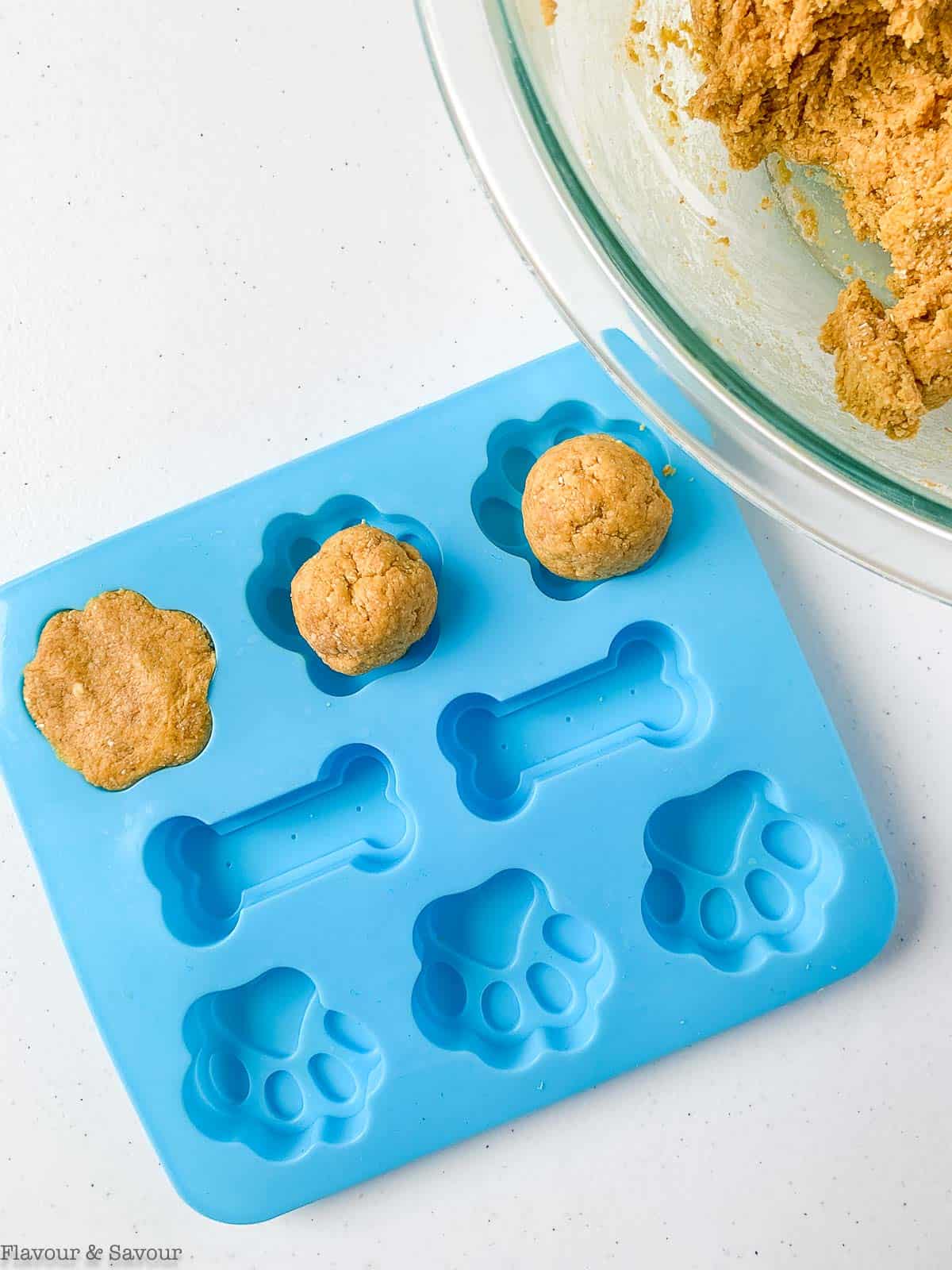 Rolling dough to place in silicone dog treat molds.