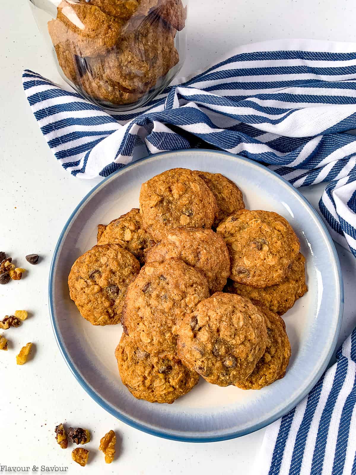 Gluten-free Banana Bread Cookies on a blue plate next to a blue-striped tea towel.