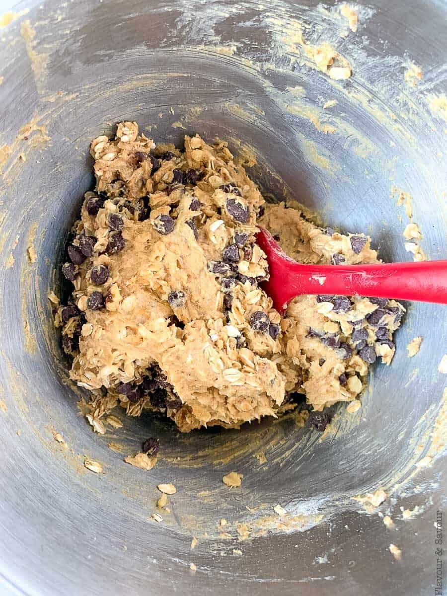 Folding chocolate chips and walnuts to cookie dough.