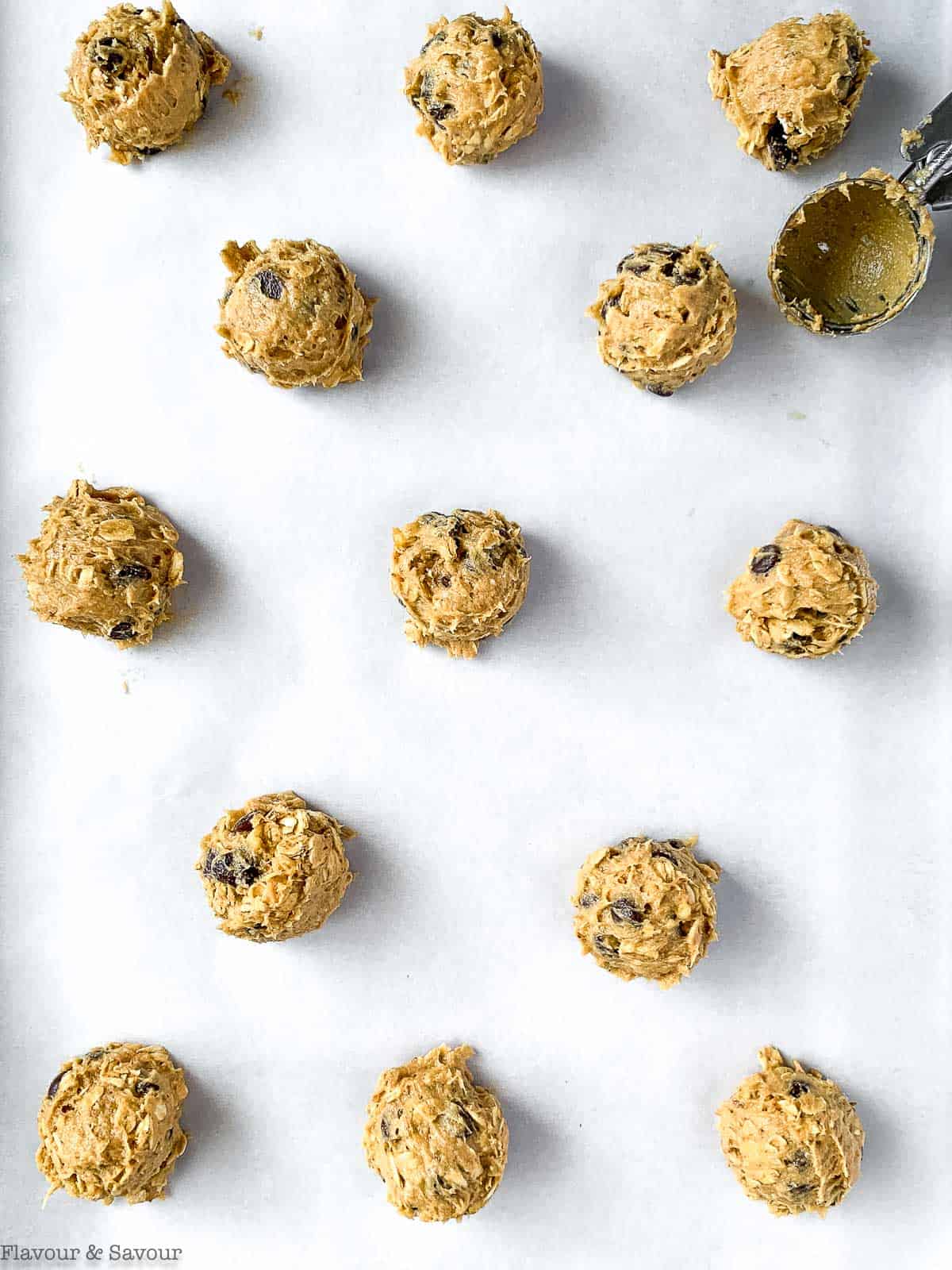 Using a cookie scoop to place mounds of cookie dough on a baking sheet.