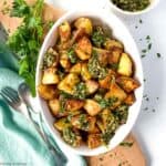 An oval bowl of crispy roasted potatoes.