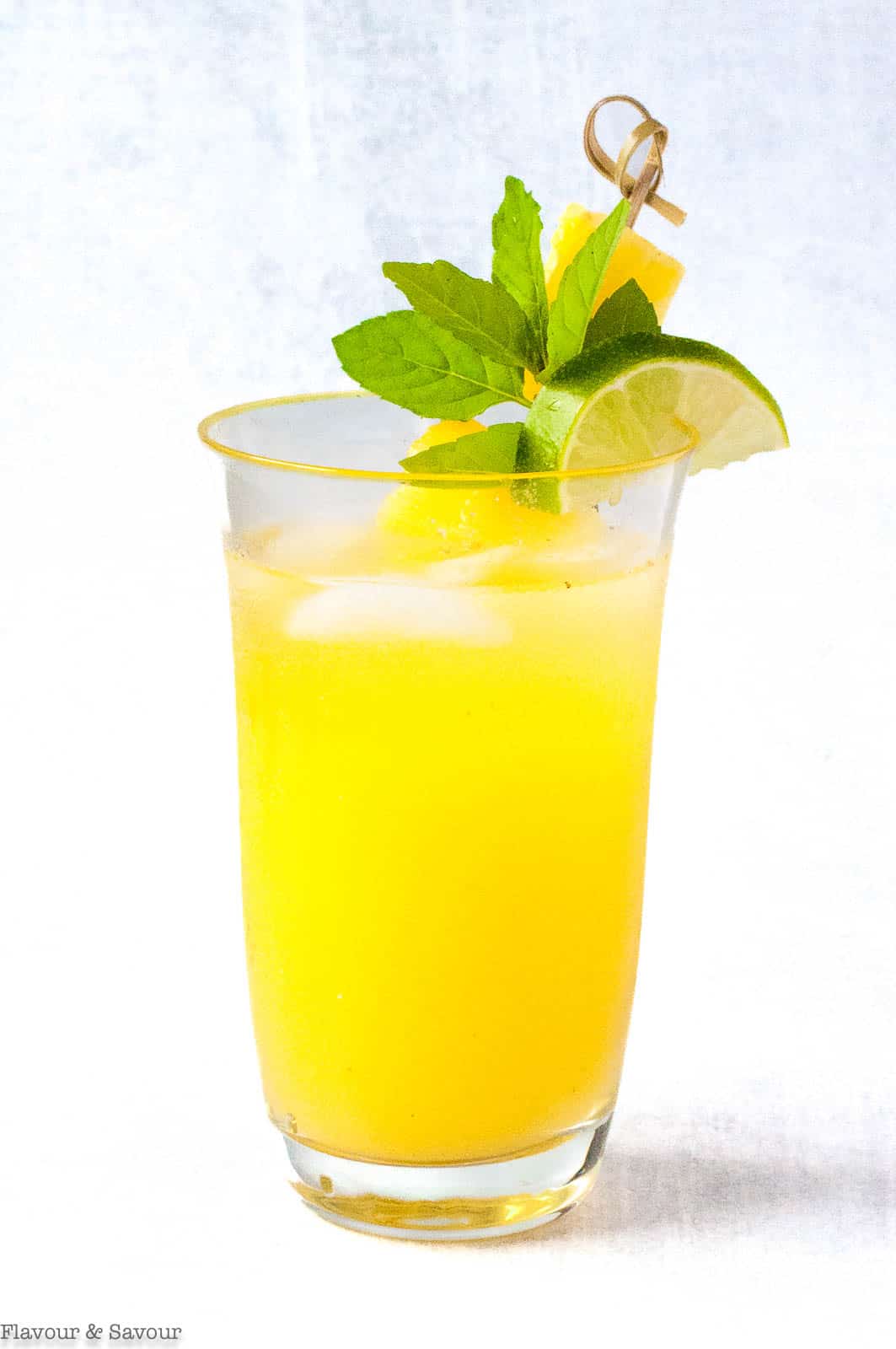 A tall glass of Pineapple Ginger Agua Fresca.