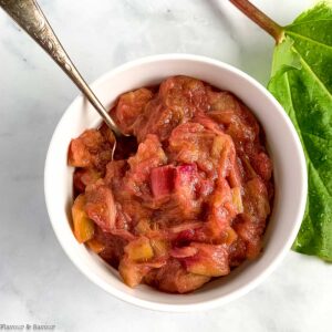 Rhubarb compote in a small bowl with a spoon.