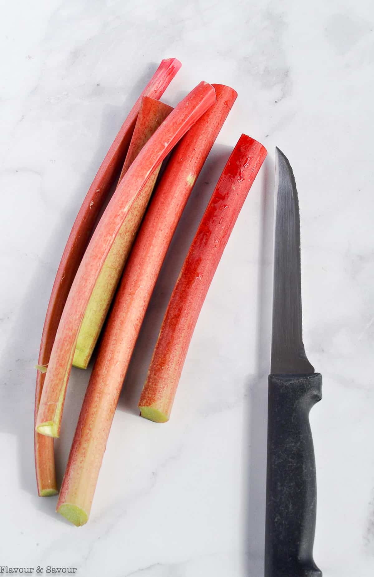 Rhubarb stalks with a knife.