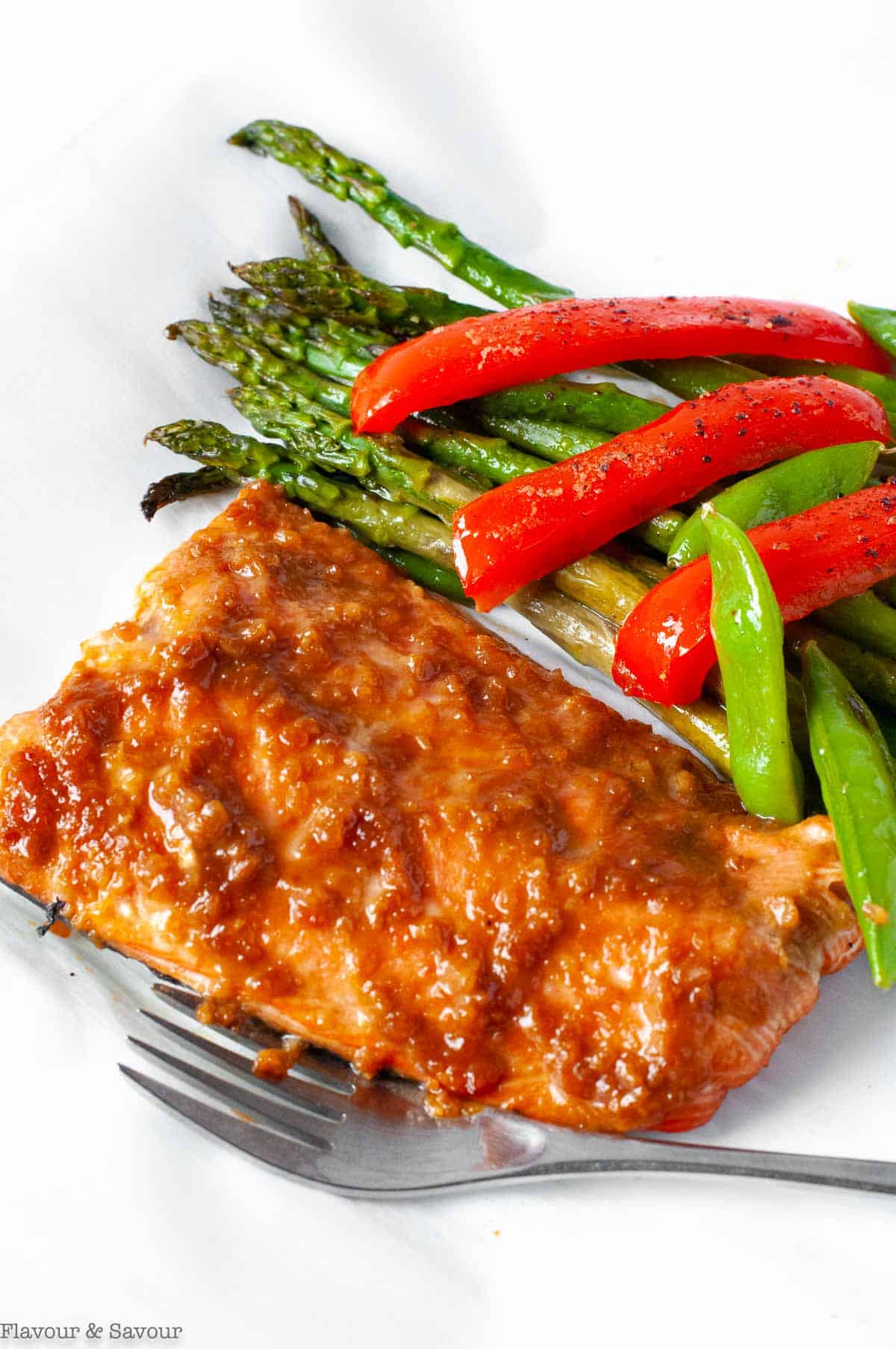 Miso Glazed Salmon fillet with asparagus, snow peas and red peppers in a foil packet.