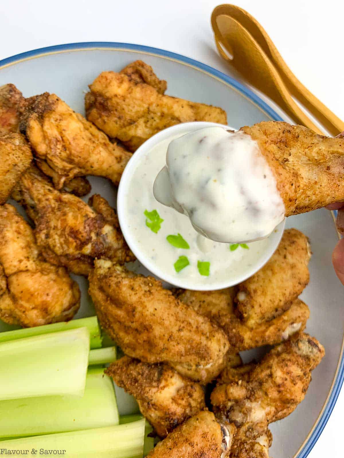 Dipping an Old Bay chicken wing in blue cheese sauce.