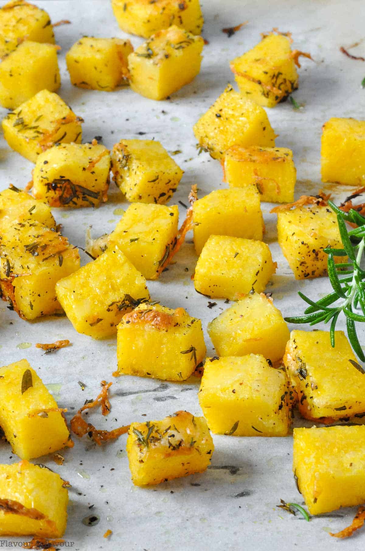 Oven-baked herbed polenta croutons on a baking sheet.