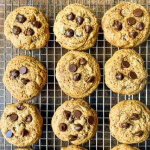 Gluten-free chewy chocolate chip cookies on a cooling rack.