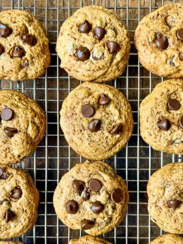 Gluten-free chewy chocolate chip cookies on a cooling rack.