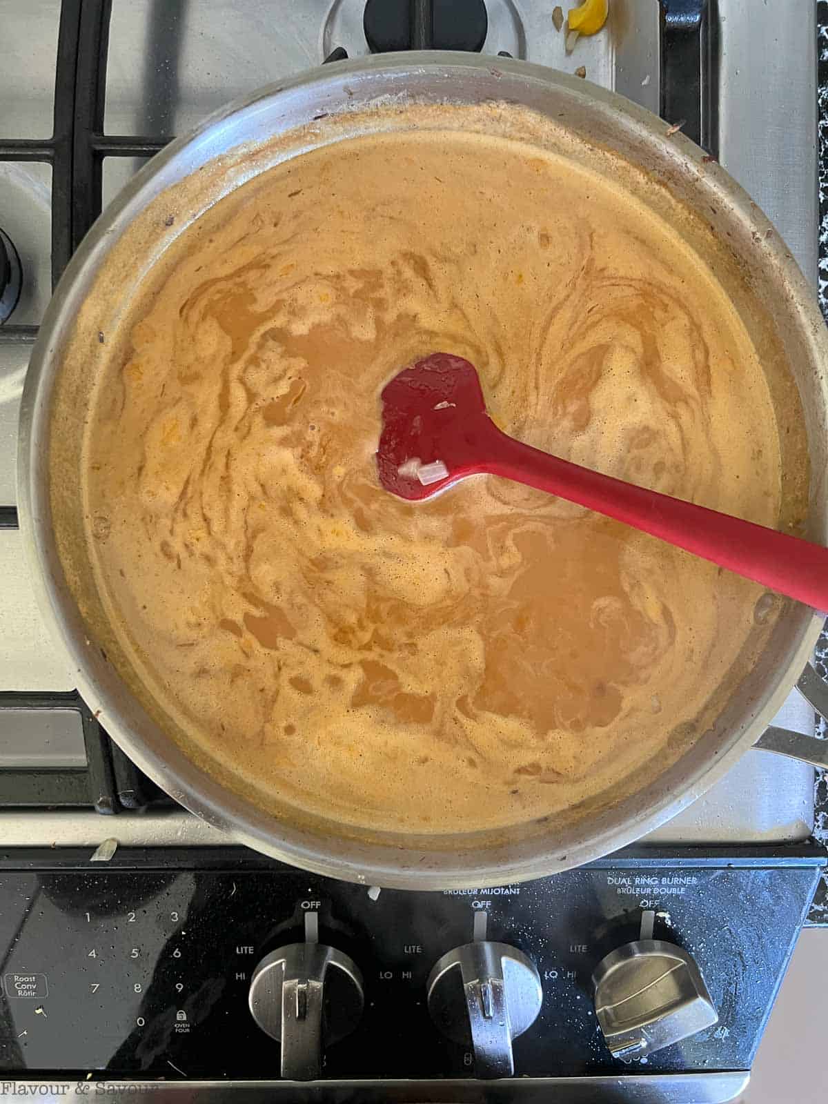 Reducing Thai red curry sauce on the stovetop.