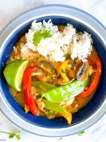 Overhead view of a bowl of Thai red curry with chicken and rice.