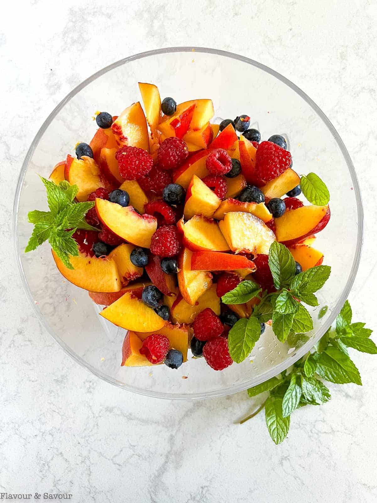Nectarines and berries in a bowl with mint.