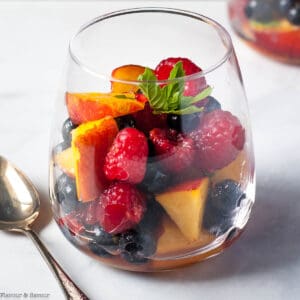 A dessert glass filled with nectarines and berries in Prosecco.
