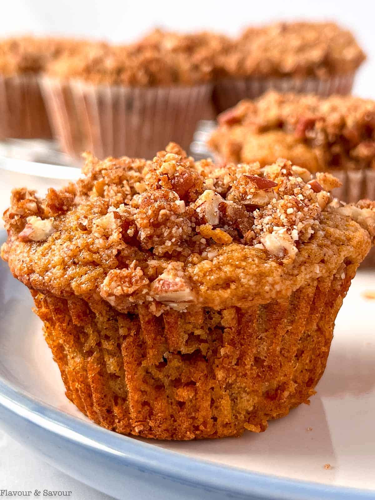 Close up view of a glutlen-free almond flour muffin showing the maple pecan streusel topping.