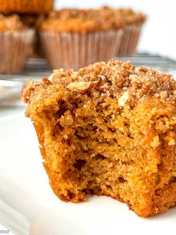 An almond flour pumpkin muffin with a bite out of it.
