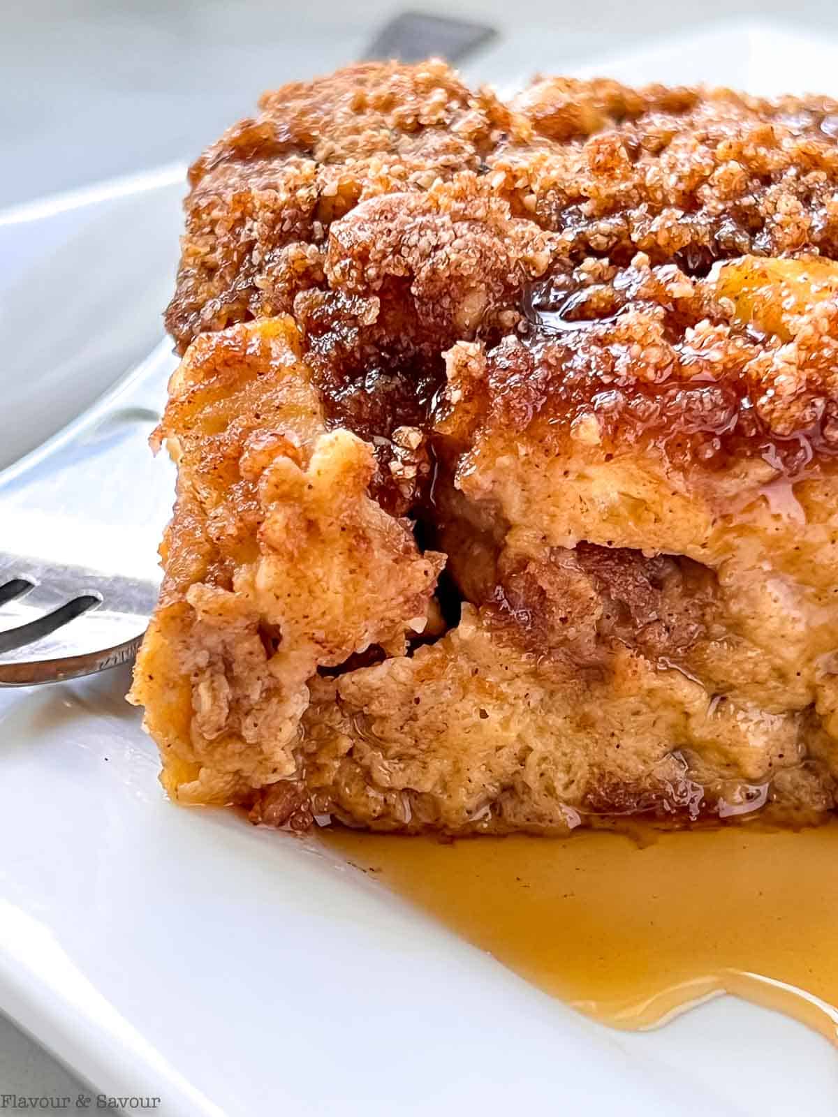 Close up view of a slice of gluten-free apple cinnamon French toast casserole with a fork.