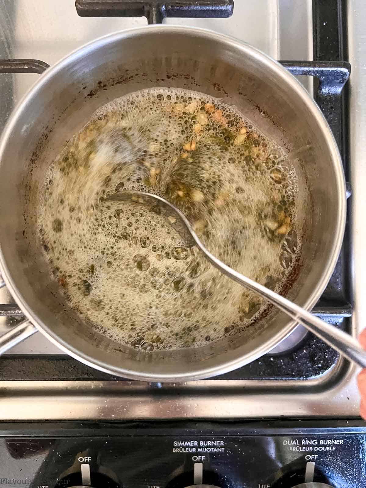 Sage browned butter sauce in a saucepan on the stovetop.