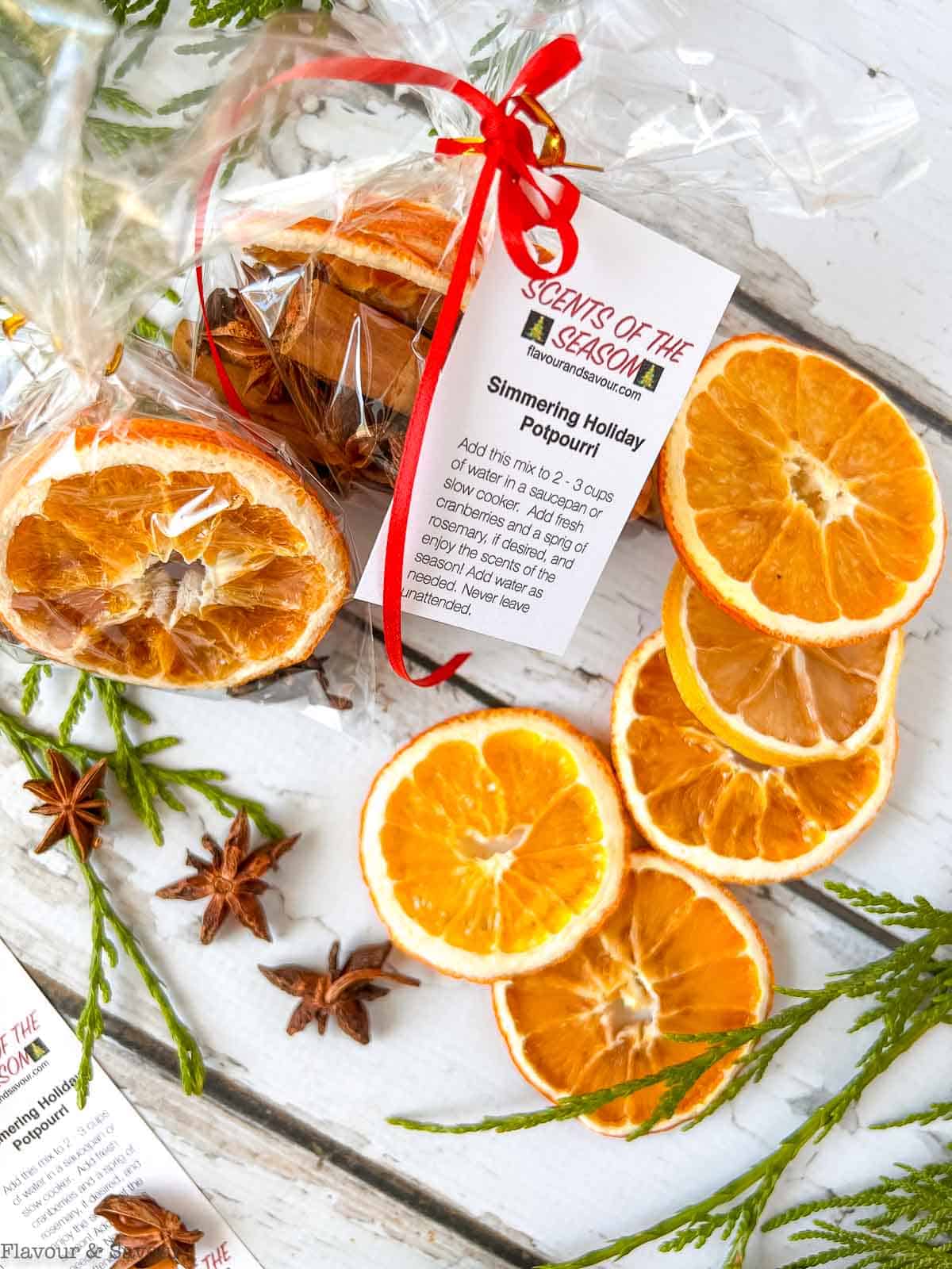 Dried orange slices and a package of simmering holiday spice mix with a gift tag.