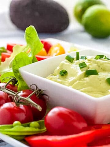 A dish of green goddess dip with fresh vegetables for dipping.