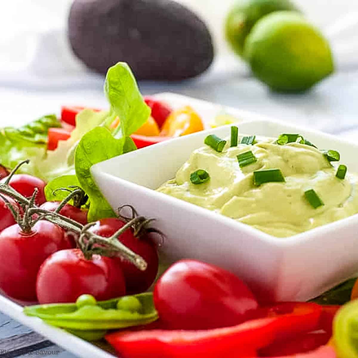 A dish of green goddess dip with fresh vegetables for dipping.