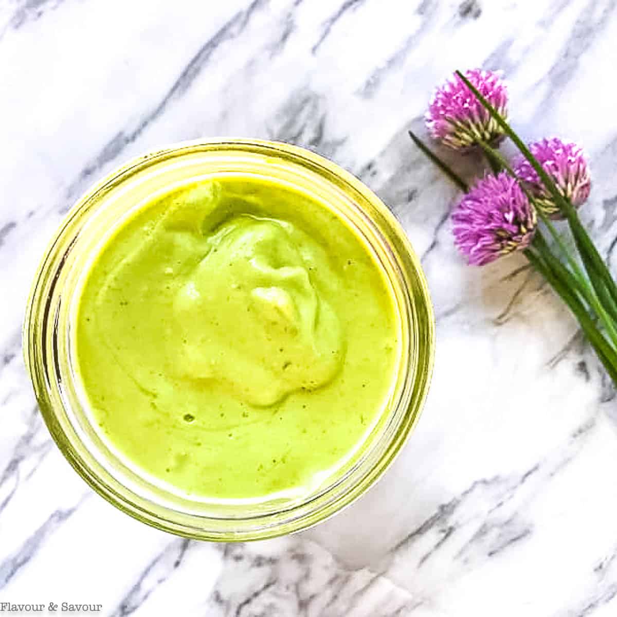 Overhead view of a jar filled with green goddess dip.