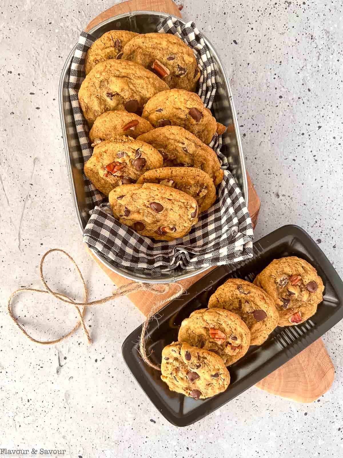 Overhead view of a basket and a plate with gluten-free pumpkin pecan cookies with chocolate chips.