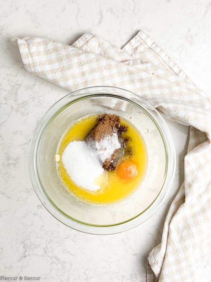 A glass bowl with melted butter, sugar and an egg yolk.